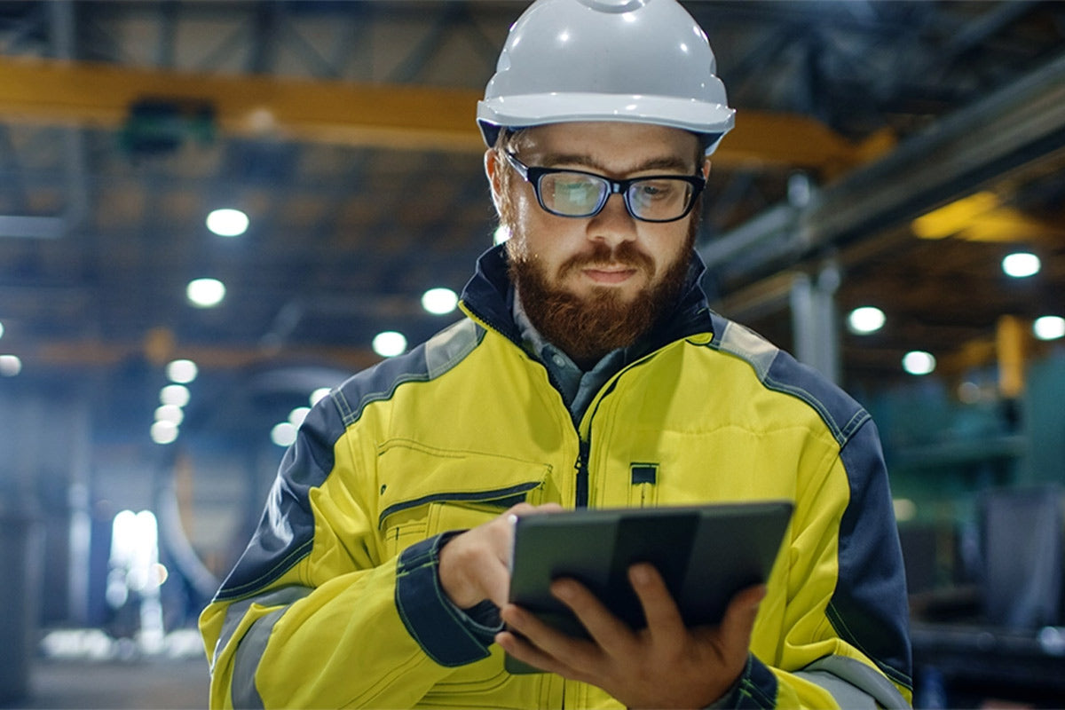Ein Mitarbeiter in einem Lagerumfeld der ein Tablet bedient